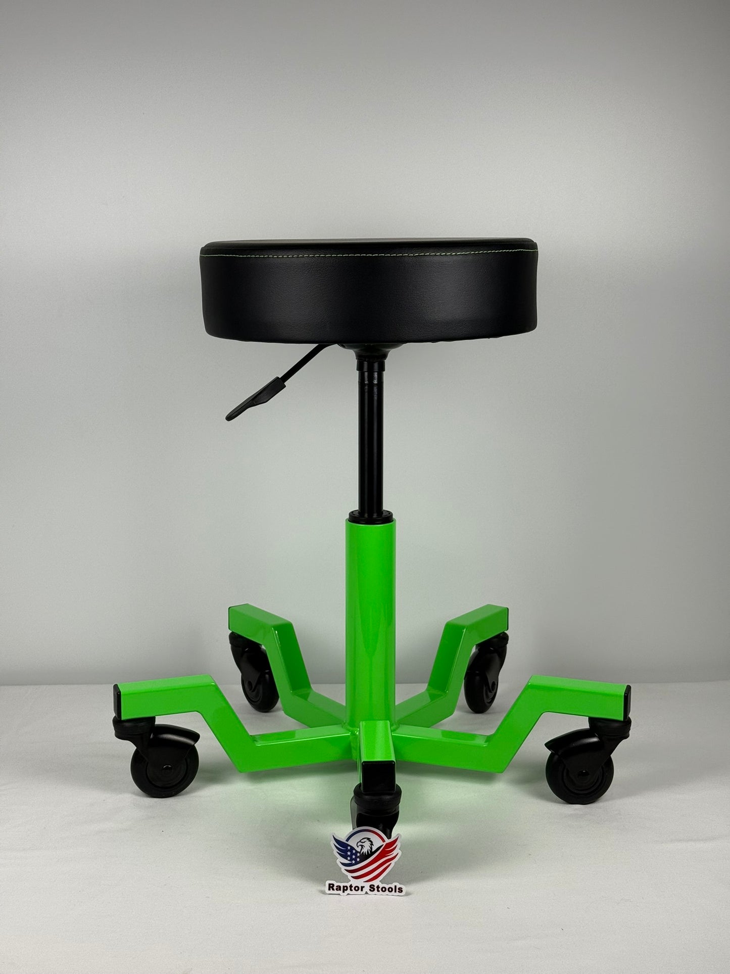 Green and black adjustable stool with wheels on a gray background