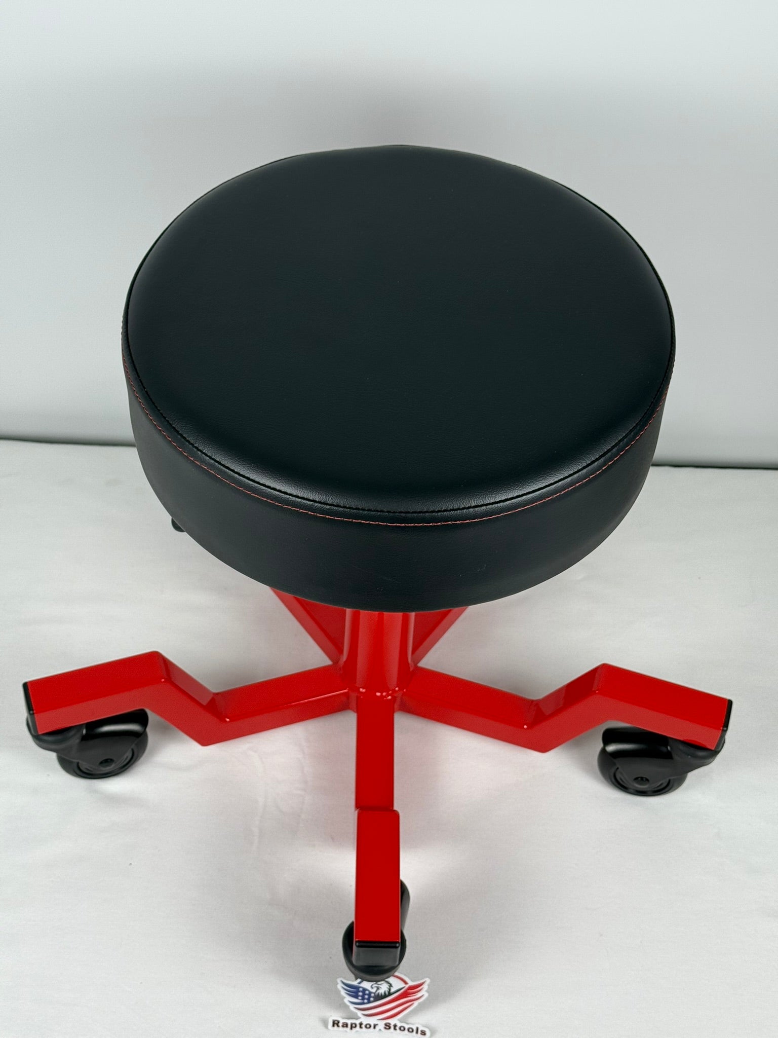 Black stool with red metal base on a white background