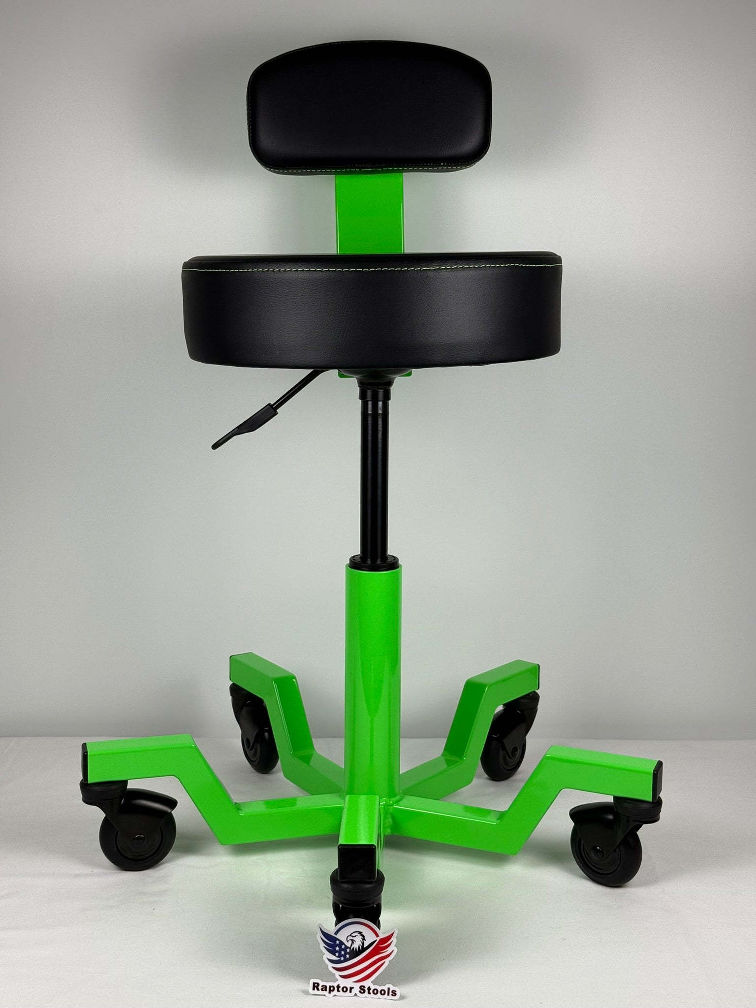 Green and black adjustable stool with wheels on a gray background