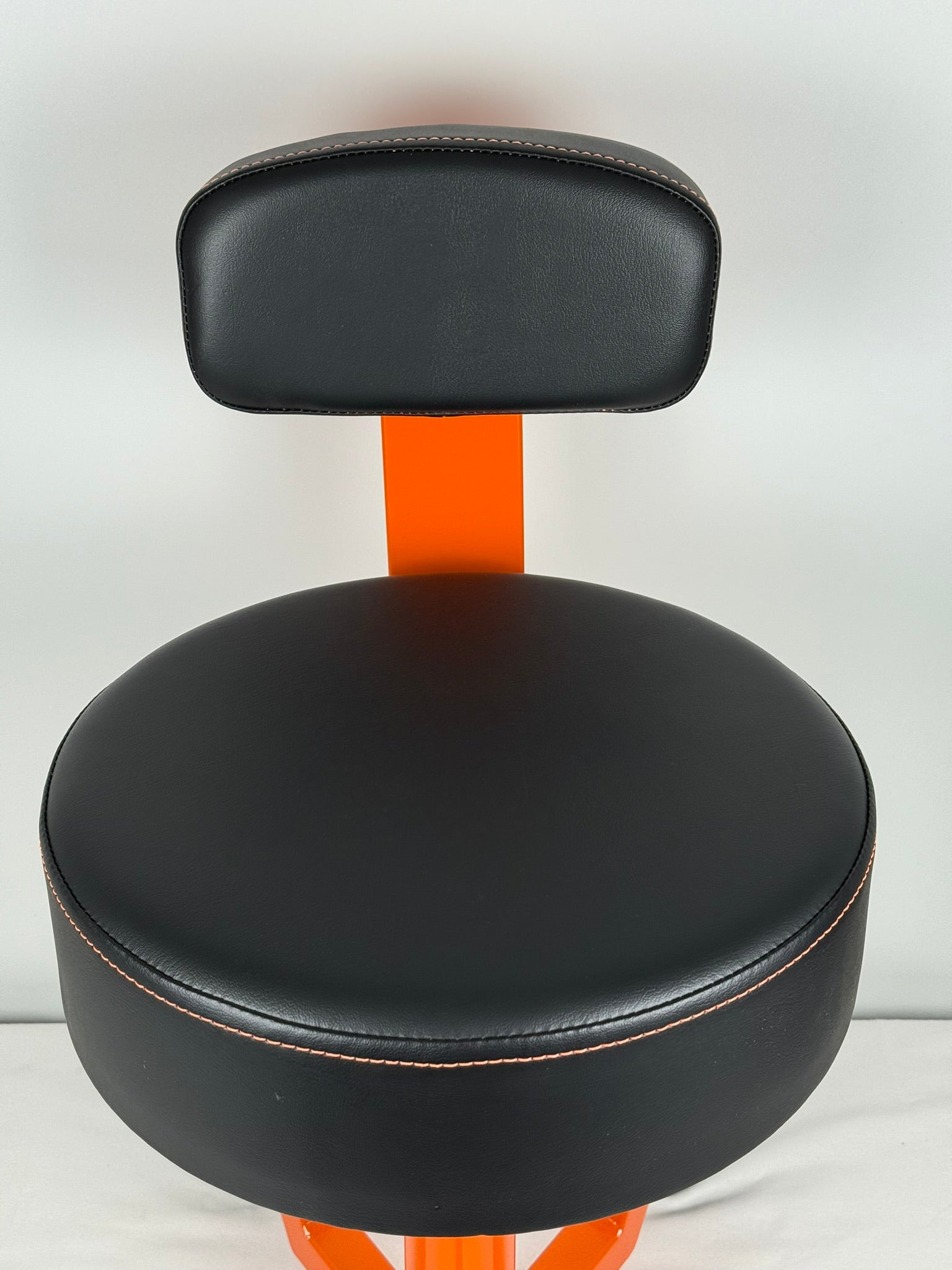 Black leather seat with orange support on a white background