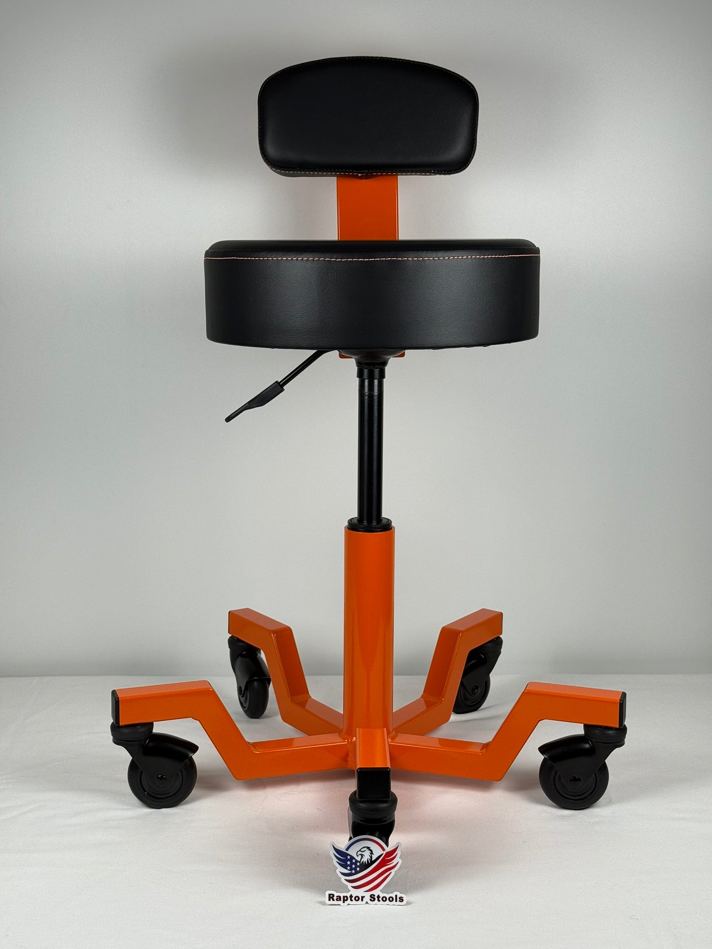 Orange and black adjustable height stool with wheels on a gray background