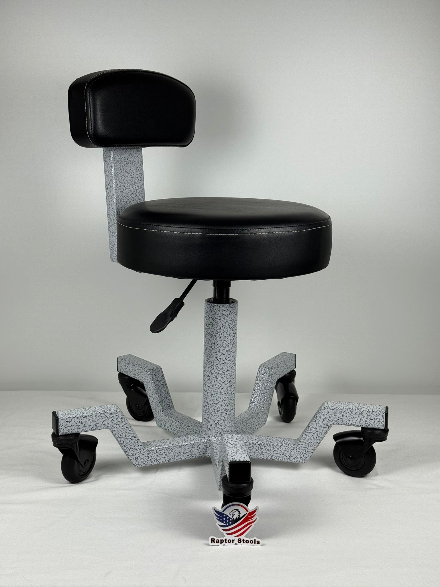 Black stool with wheels and a gray base on a white background built to out last 