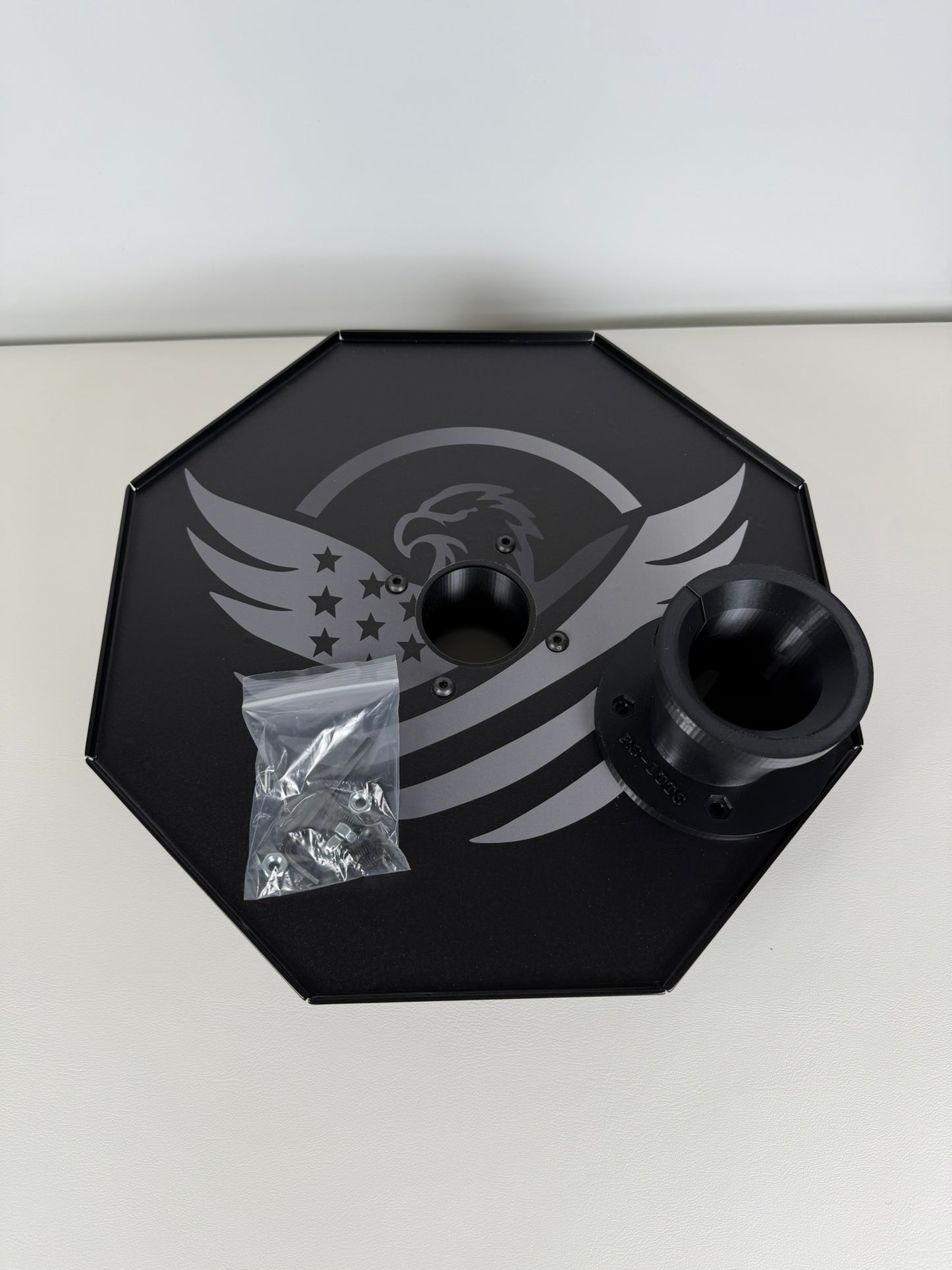 Black octagonal tool tray with a logo on a white background
