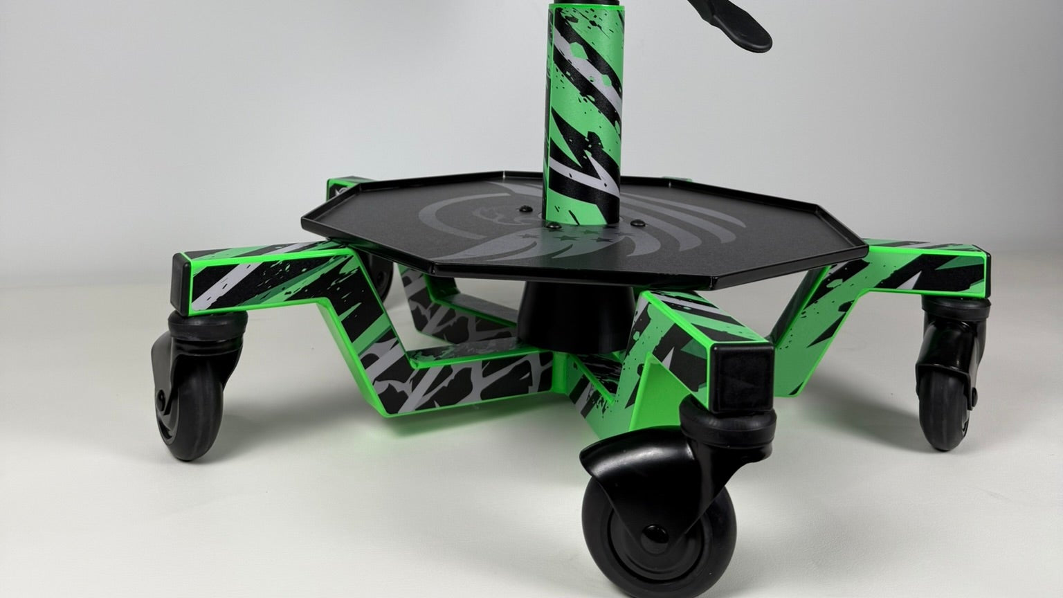Green and black wheeled device with zebra pattern on a gray background