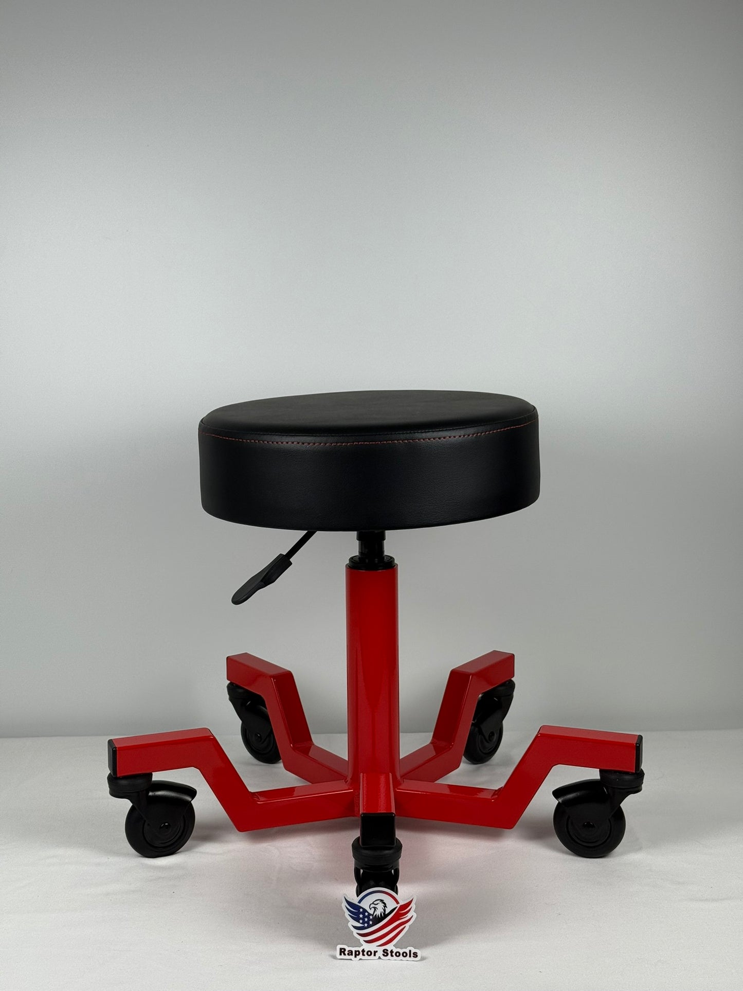 Red and black adjustable height stool on a white background